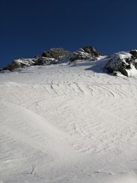 Scenic view of snowcapped mountains against clear blue sky