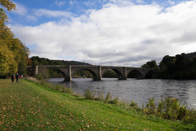 Arch bridge over river against sky