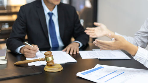 Midsection of business colleagues working on table