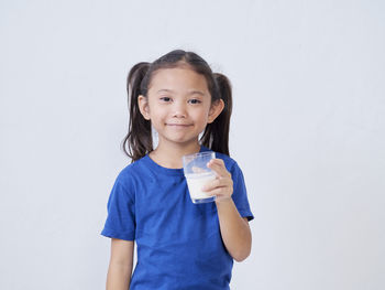 Portrait of a smiling young woman against white background
