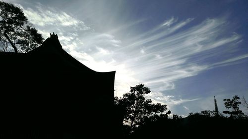 Low angle view of silhouette trees against sky