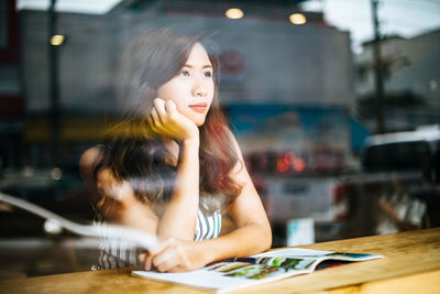 Portrait of young woman looking at camera at table