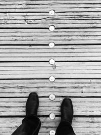 Low section of man standing on wood