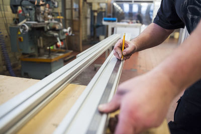 Close-up of man in factory working on metal component