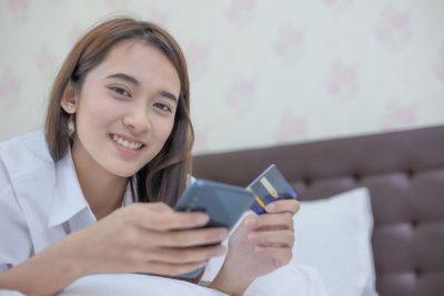 Smiling young woman using mobile phone