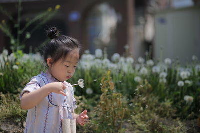 Close-up of girl blowing bubbles while standing on field