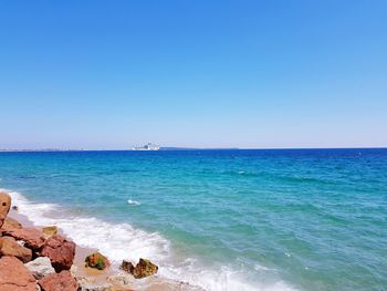 Scenic view of sea against clear blue sky