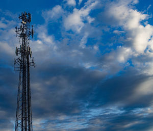 Low angle view of power lines against cloudy sky