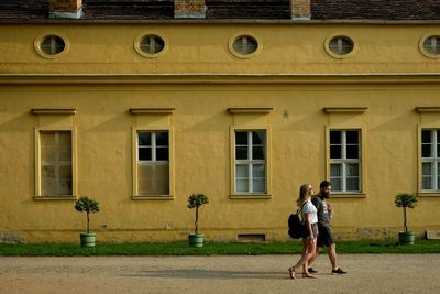 Rear view of woman walking in front of building