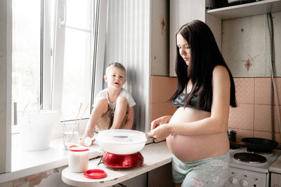 Young woman with mother and daughter in kitchen