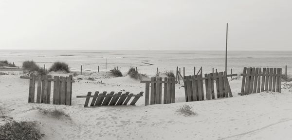 Scenic view of beach against clear sky during winter
