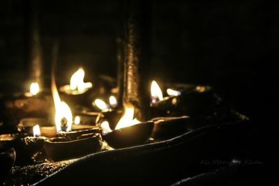 Close-up of lit candles in temple