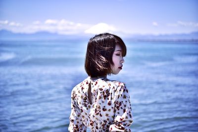 Woman looking at sea against sky