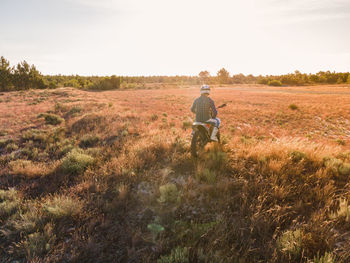 Rear view of man walking on field