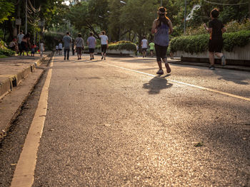 Rear view of people walking on road