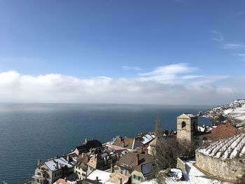 High angle view of townscape by sea against sky