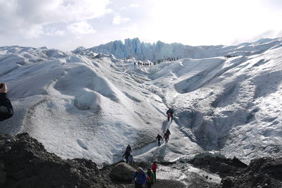 Panoramic view of people on snow covered mountain