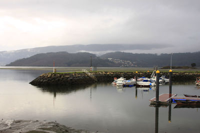 Boats moored at calm lake