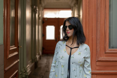 Mid adult woman standing against door