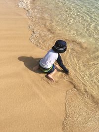 High angle view of boy playing at shore