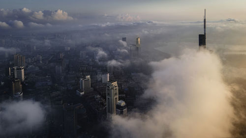 Aerial view of smoke emitting from chimney against sky