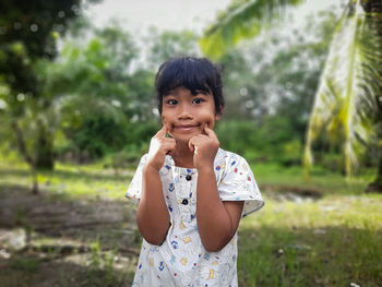 Young woman drinking water while standing outdoors