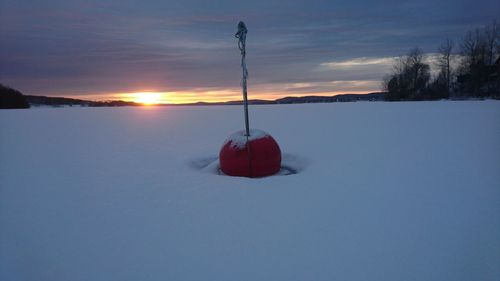 Scenic view of frozen lake against sky during sunset