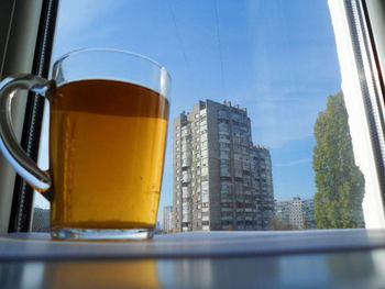 Low angle view of glass of building against sky