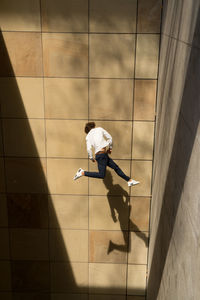 Man jumping against tiled floor