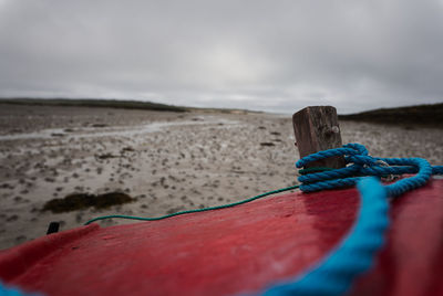 Close-up of rope on beach against sky