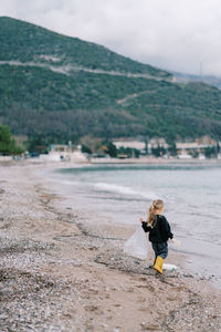 Rear view of woman walking on beach