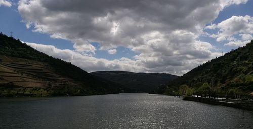 Scenic view of river amidst mountains against sky