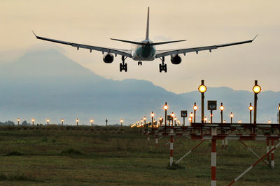 Low angle view of airplane flying against sky during sunset