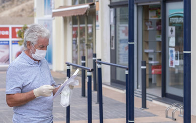 Man holding paper standing outdoors