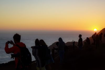 People at beach during sunset