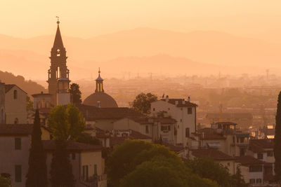 View of buildings in city at sunset