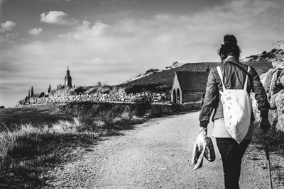 Rear view of man and woman walking against sky