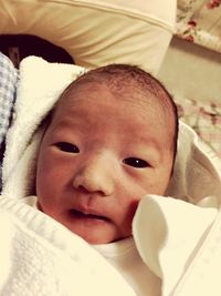 Portrait of cute baby lying on bed