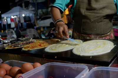 Midsection of man preparing food at restaurant