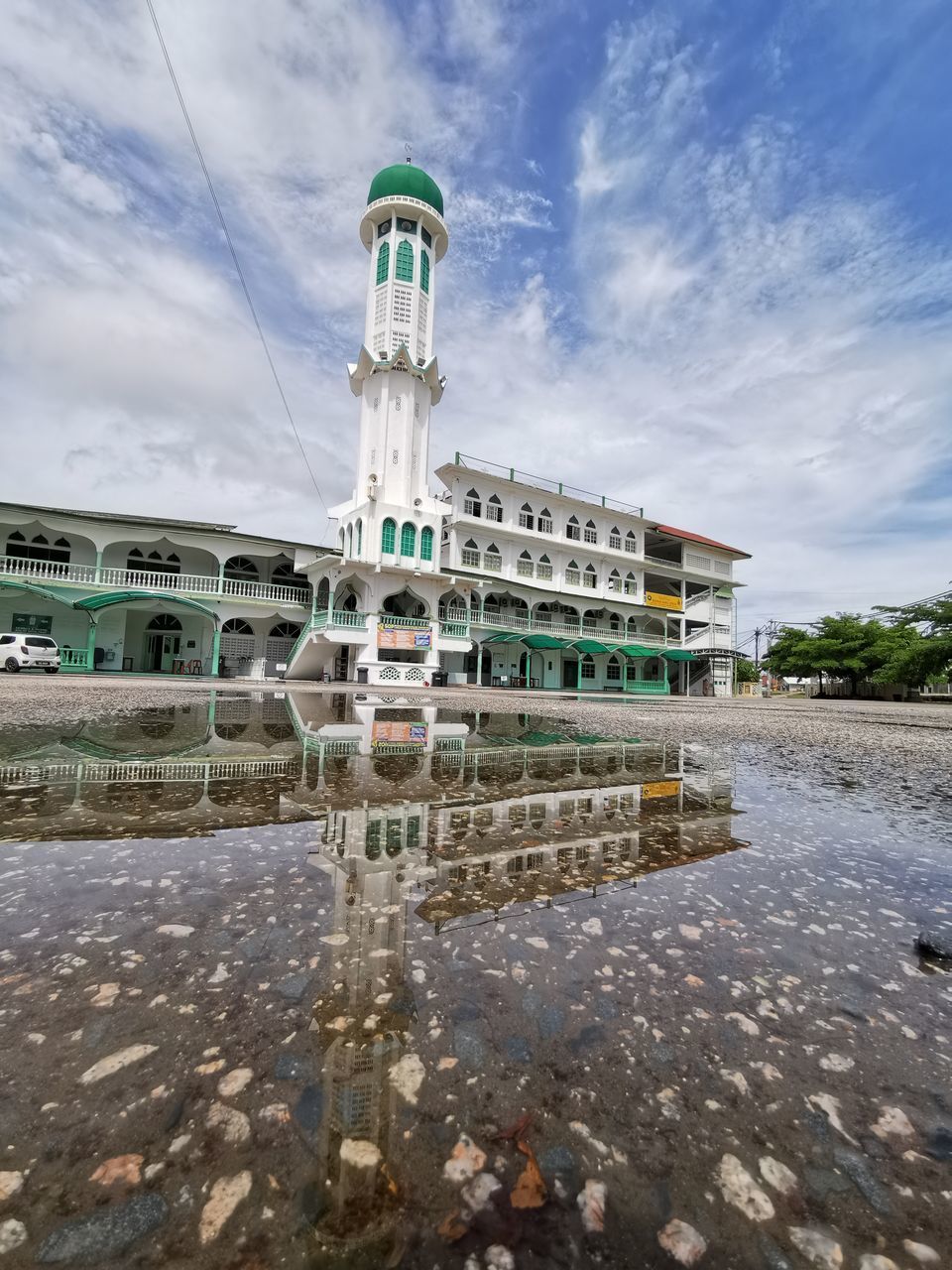 REFLECTION OF BUILDINGS IN PUDDLE ON STREET