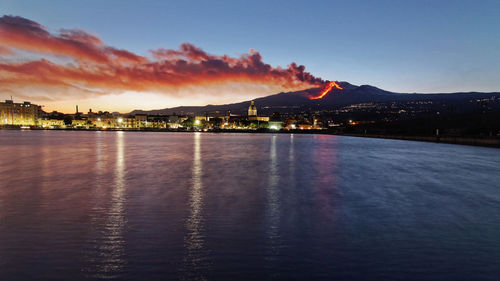 Scenic view of sea against sky at dusk during etna eruption