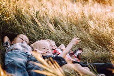 Close-up of siblings lying on grass