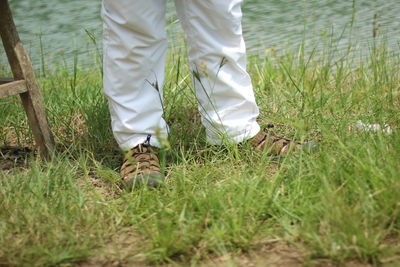 Low section of man standing on field