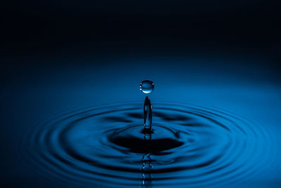 Close-up of water drop against blue sky