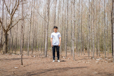 Full length portrait of man standing in forest