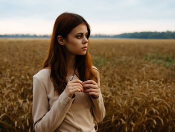 Young woman with arms raised on field