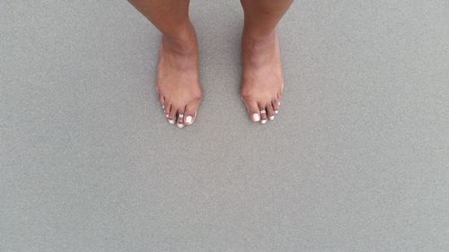 Low section of woman standing on tiled floor