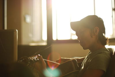 Man playing guitar at home