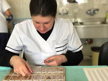 Female scientist examining microscope slide at laboratory