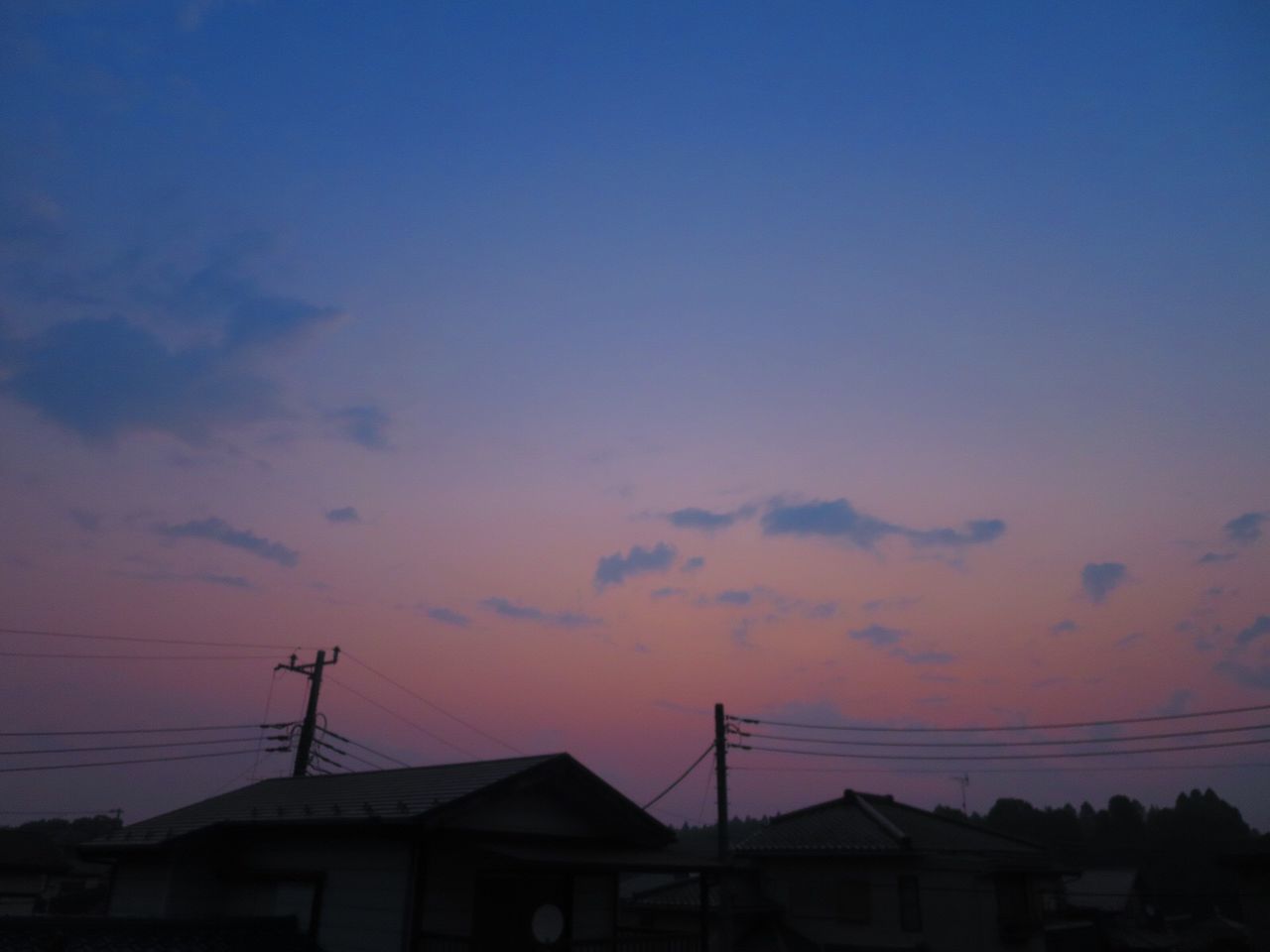 SILHOUETTE HOUSES AGAINST SKY AT SUNSET